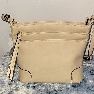 Cream color medium crossbody purse. With lots of pockets.